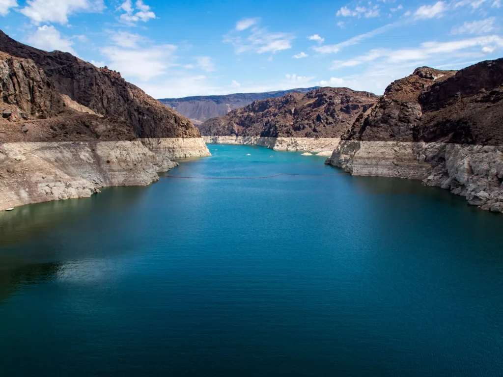 Lake Mead showing critically low water levels with a prominent white bathtub ring along the rocky canyon walls